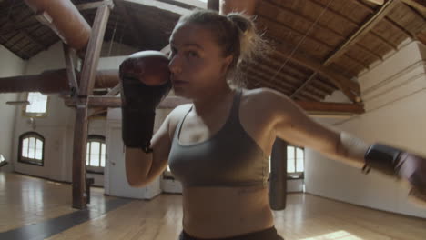 Handheld-shot-of-woman-in-boxing-gloves-punching-to-camera